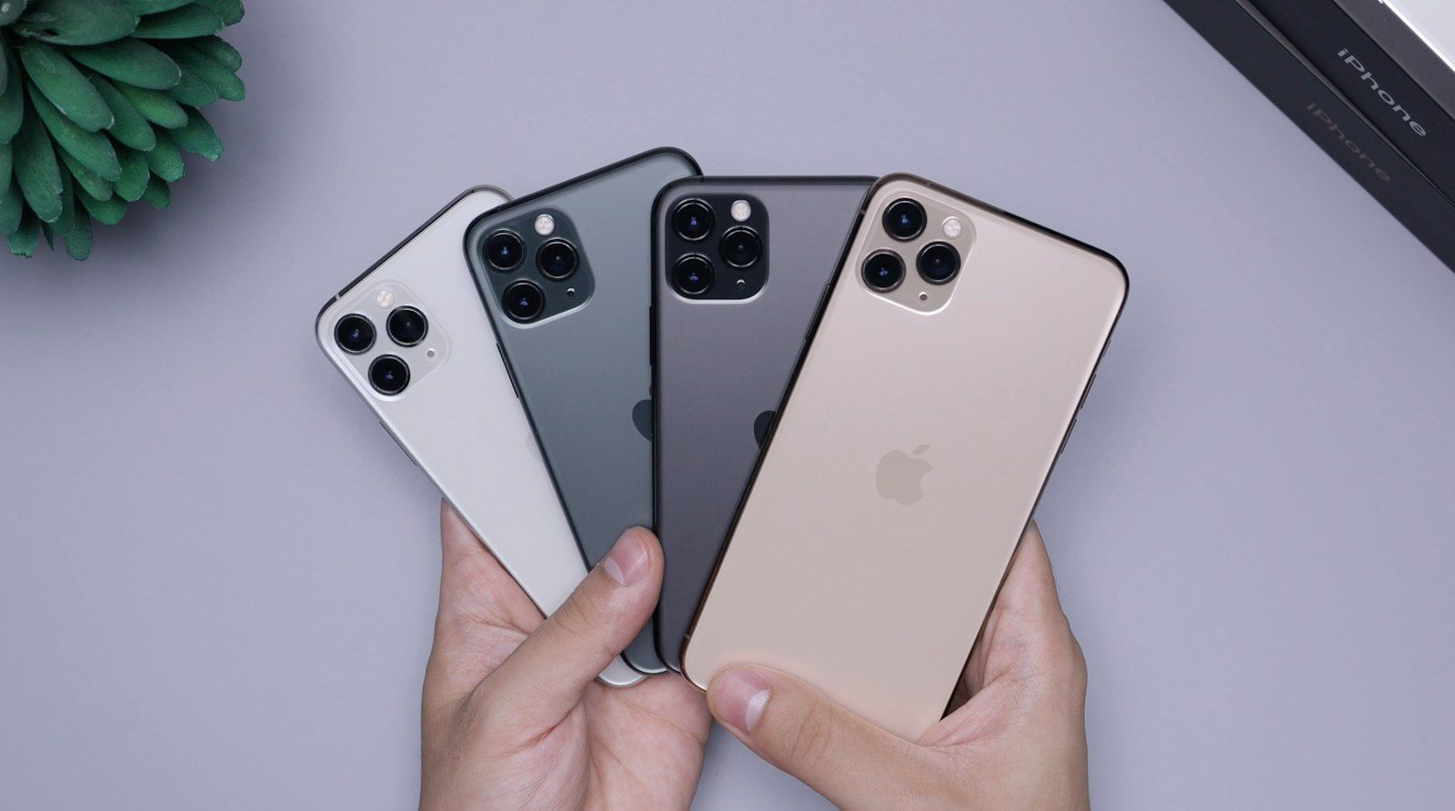 Four iPhones fanned out in a hand